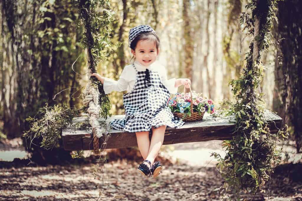 cute little girl on a swing with a basket