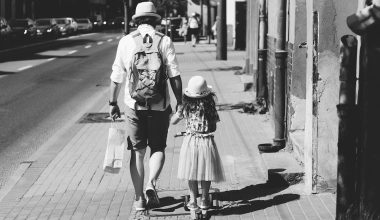 father and daughter walking on the sidewalk