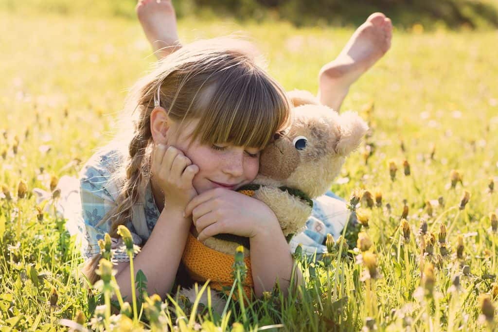 girl hugging teddy bear