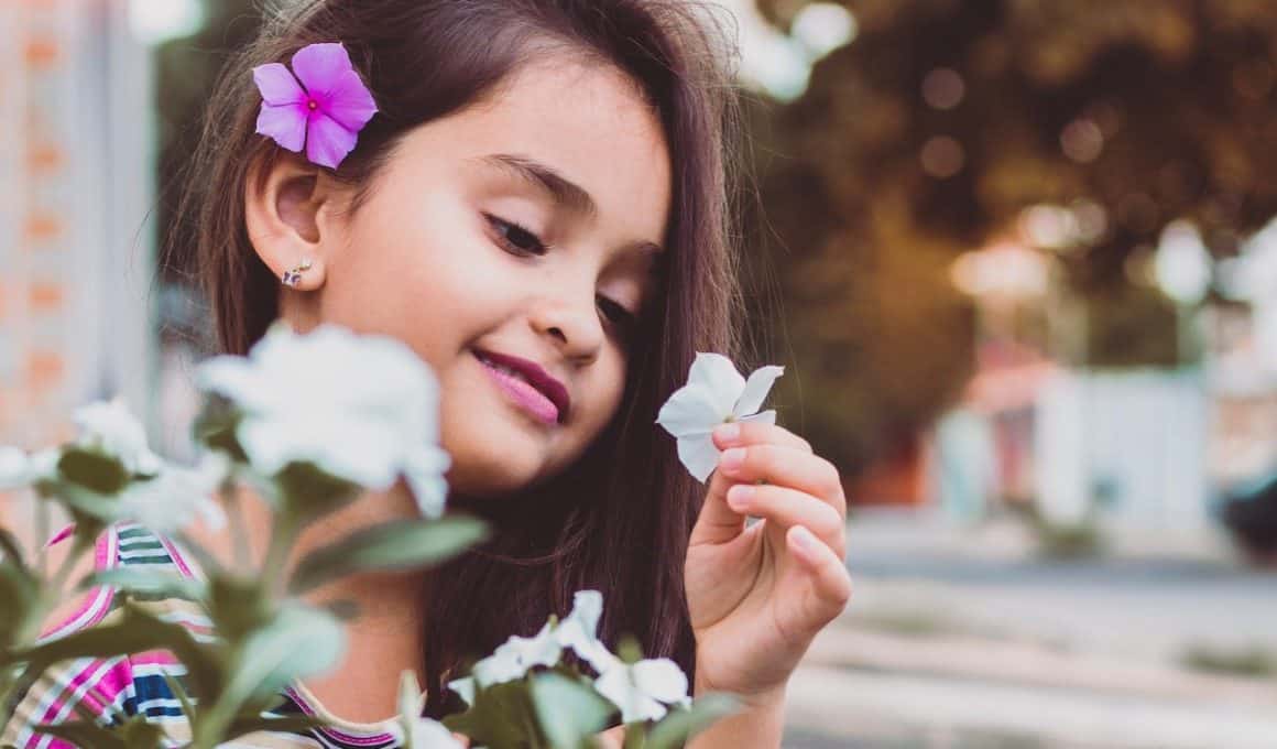 girl looking at flower