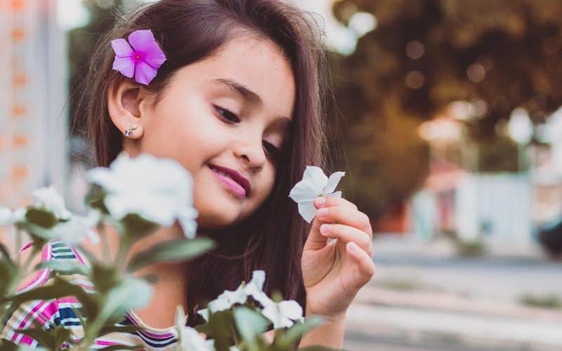 girl looking at flower