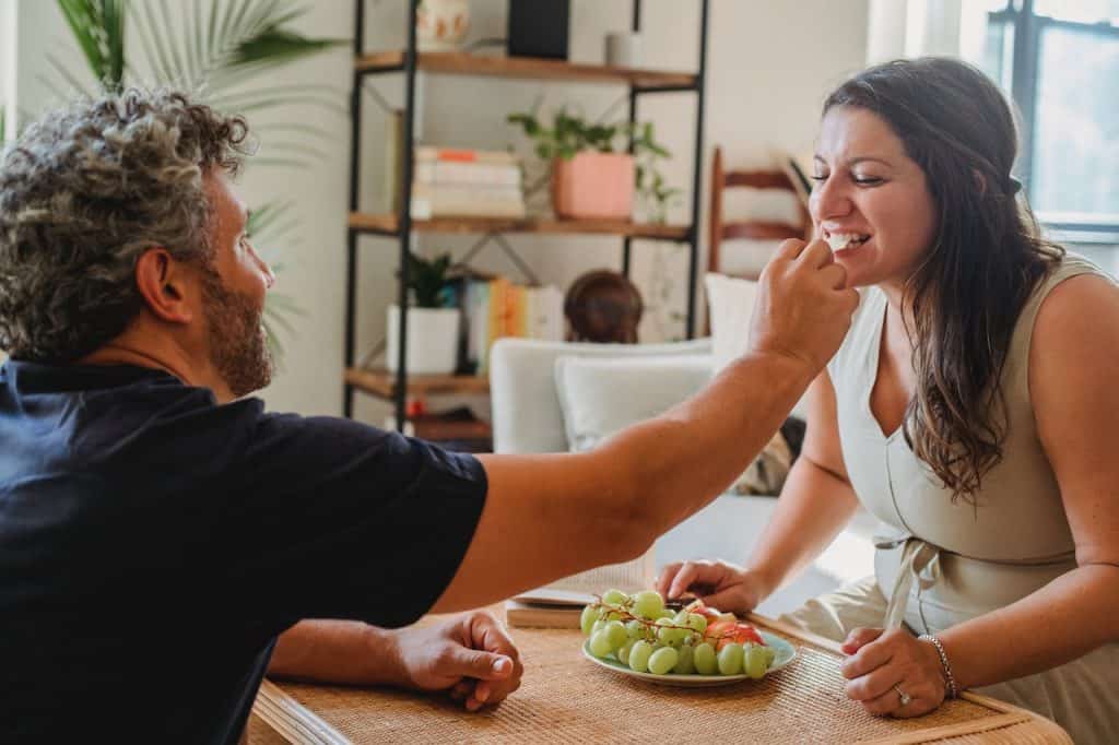 husband feeding grapes to his wife