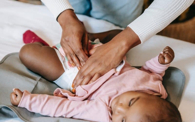 lady putting diaper on baby