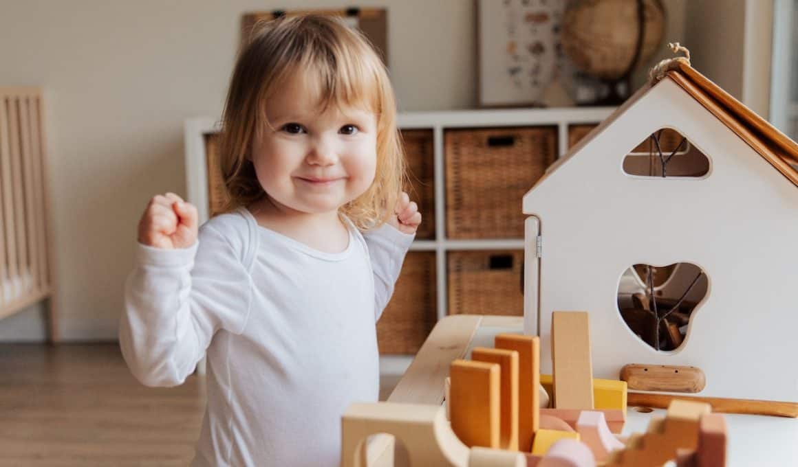 little girl playing with doll house