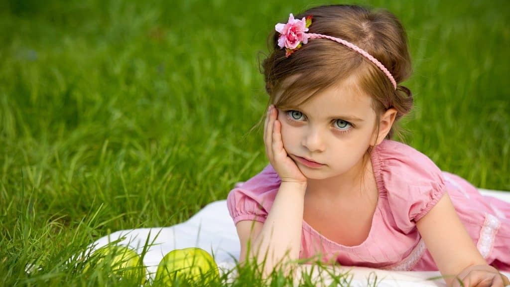 little girl sitting on grass