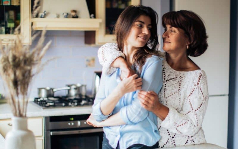mother hugging daughter from behind