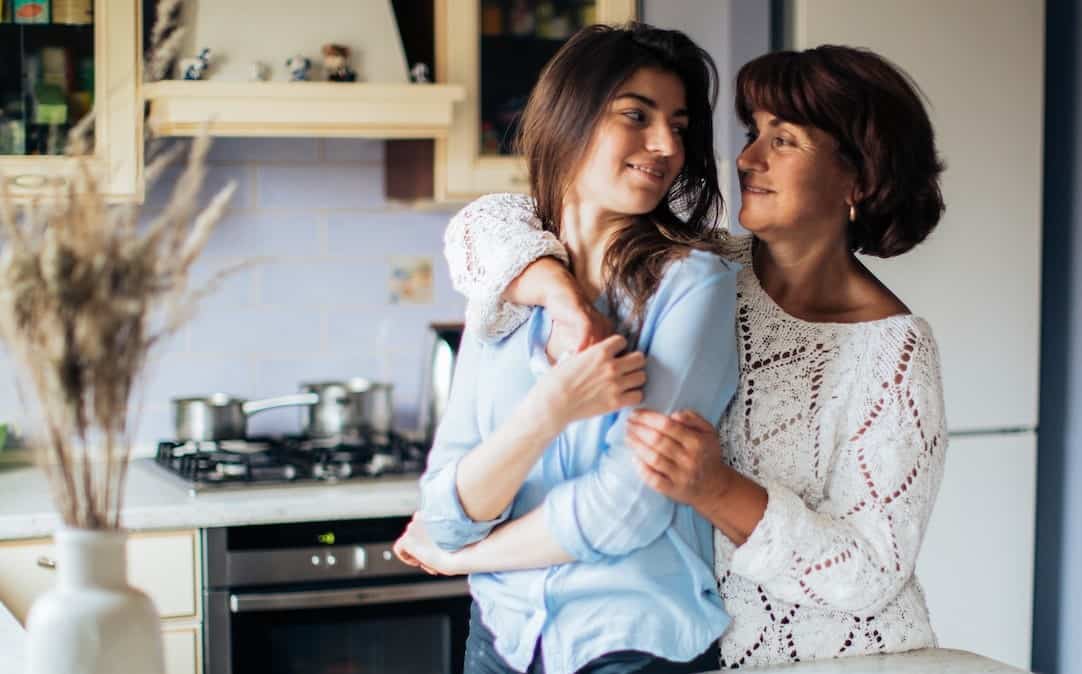 mother hugging daughter from behind