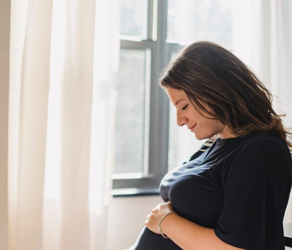 pregnant woman touching her belly