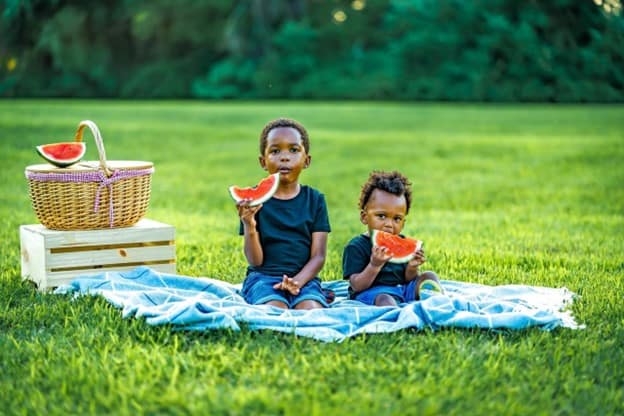 two kids eating watermelon