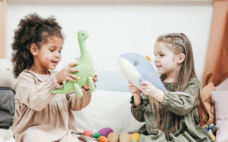 two little girls playing with stuffed toys