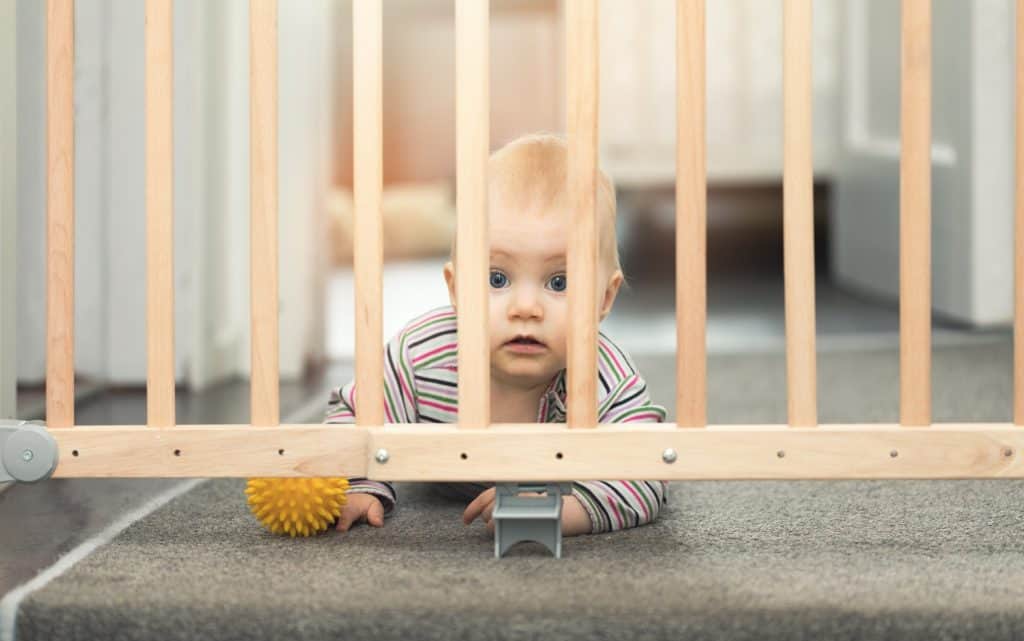 baby behind wooden gates