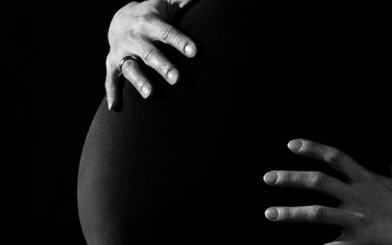 greyscale photo of a pregnant woman