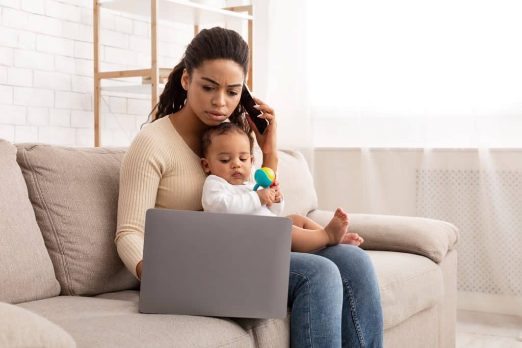 mom using laptop while carrying baby