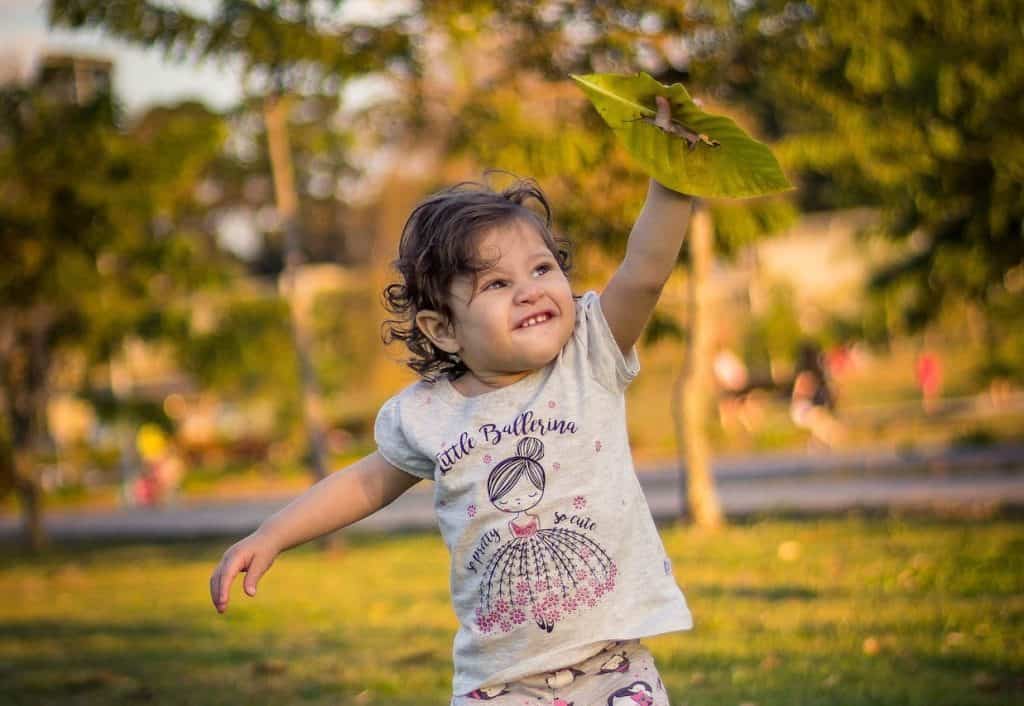 toddler playing with a leaf