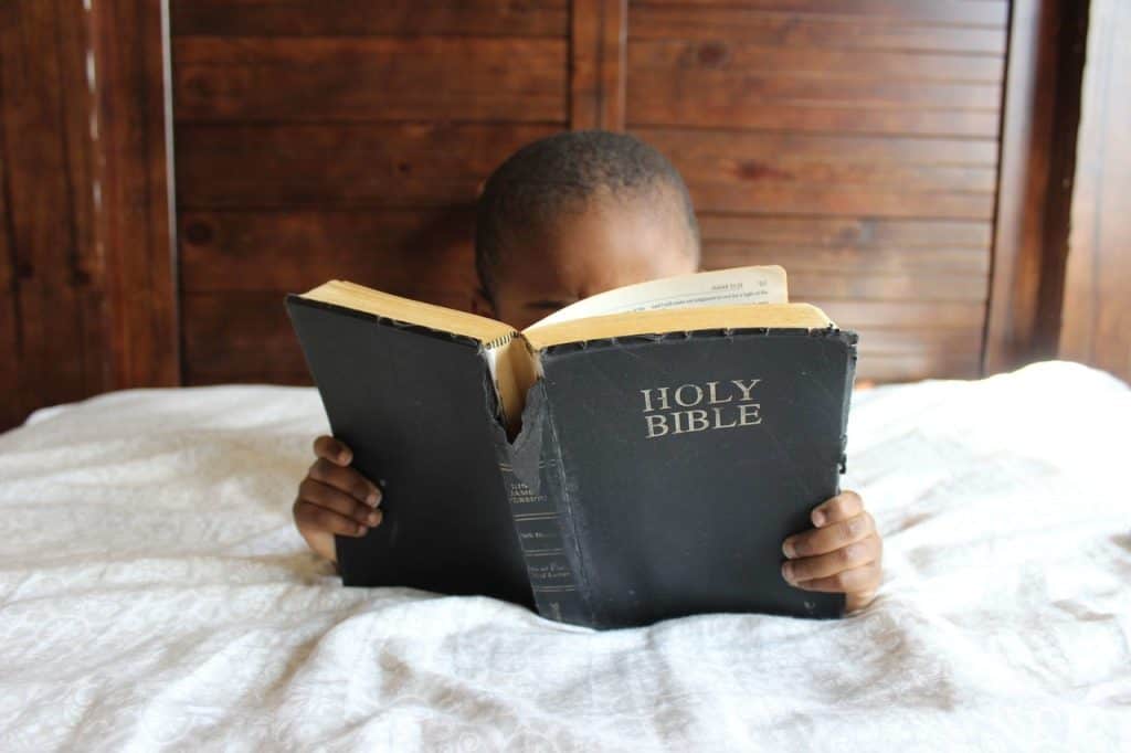 toddler reading a bible