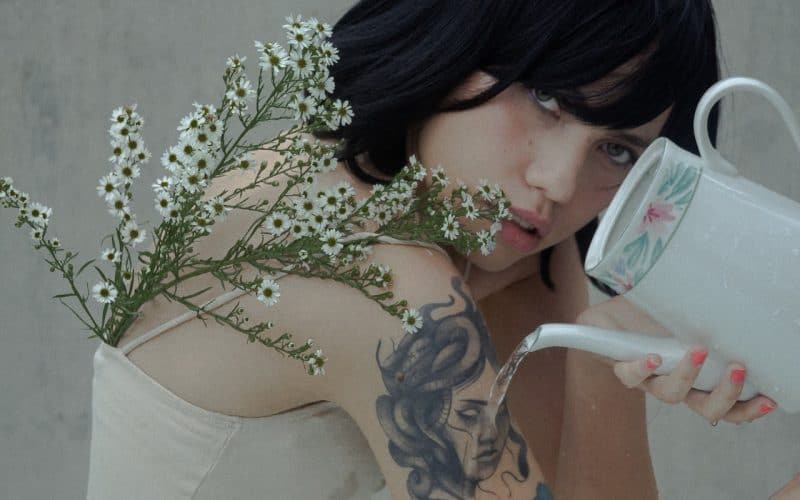 woman pouring kettle on her tattoos