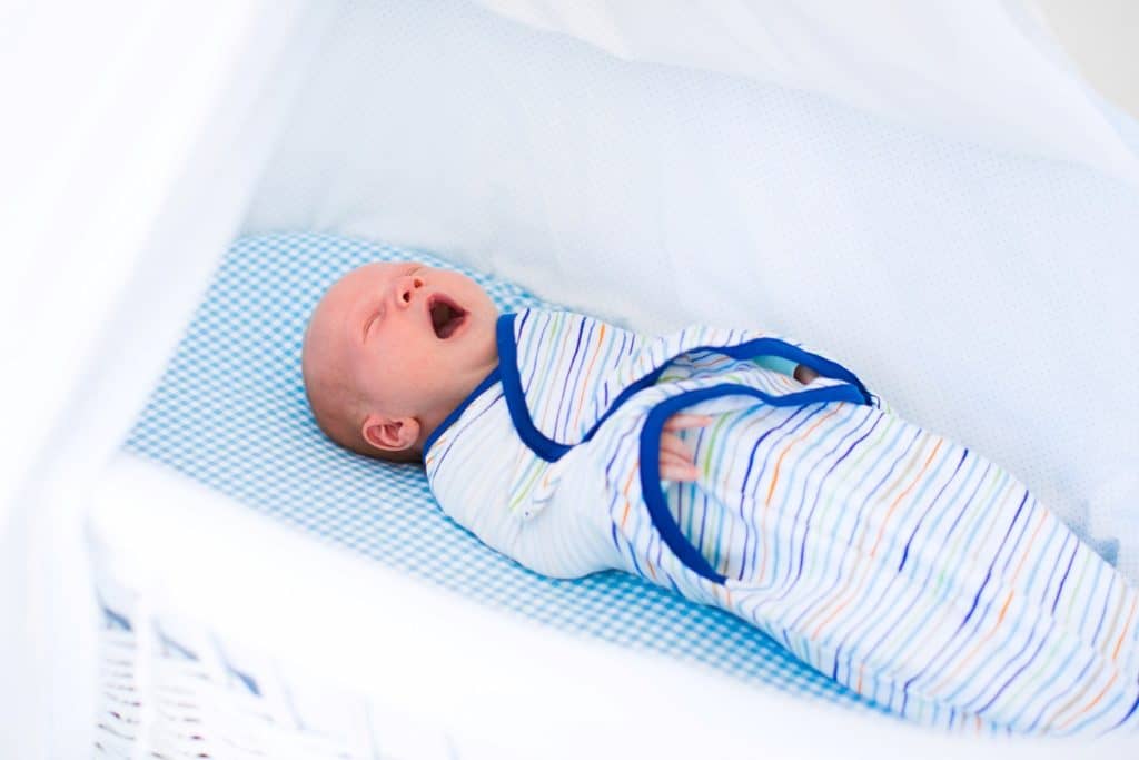 baby on a swaddle yawning