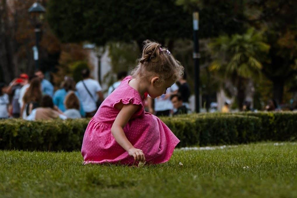 girl in pink dress playing outdoor