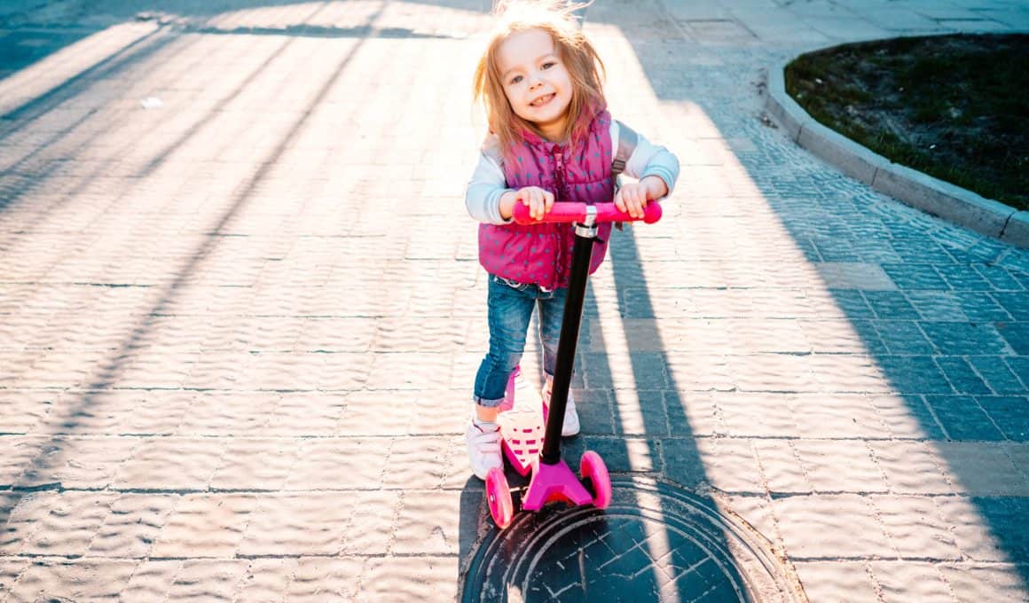 little girl riding on a scooter