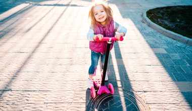 little girl riding on a scooter