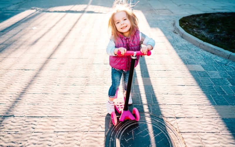 little girl riding on a scooter