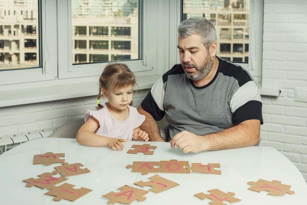 man doing puzzles with his daughter