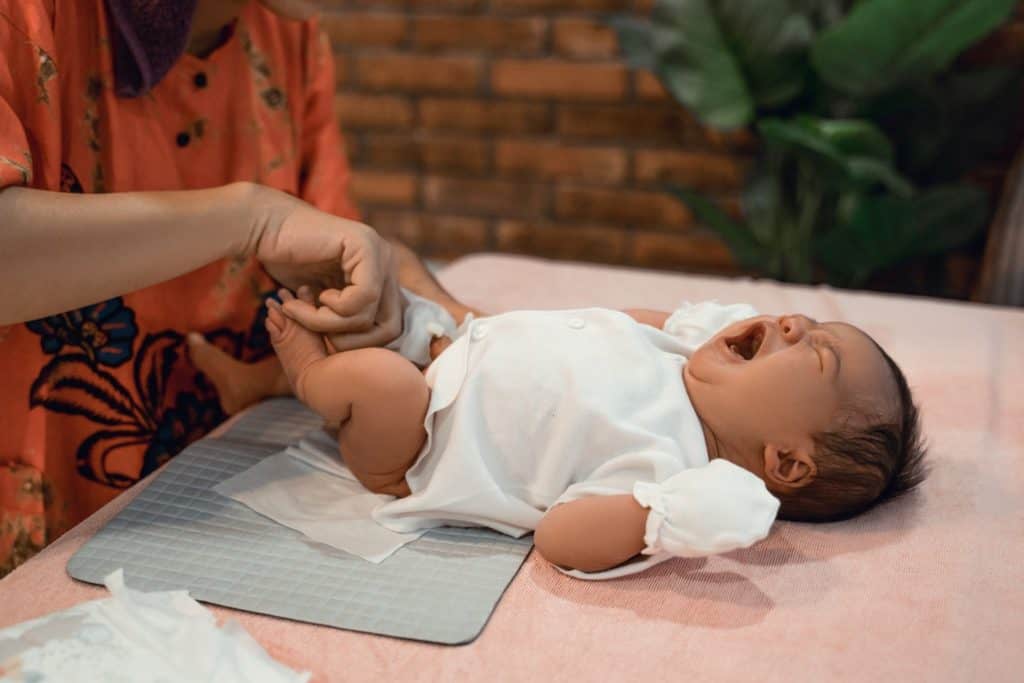 mom changing baby diaper