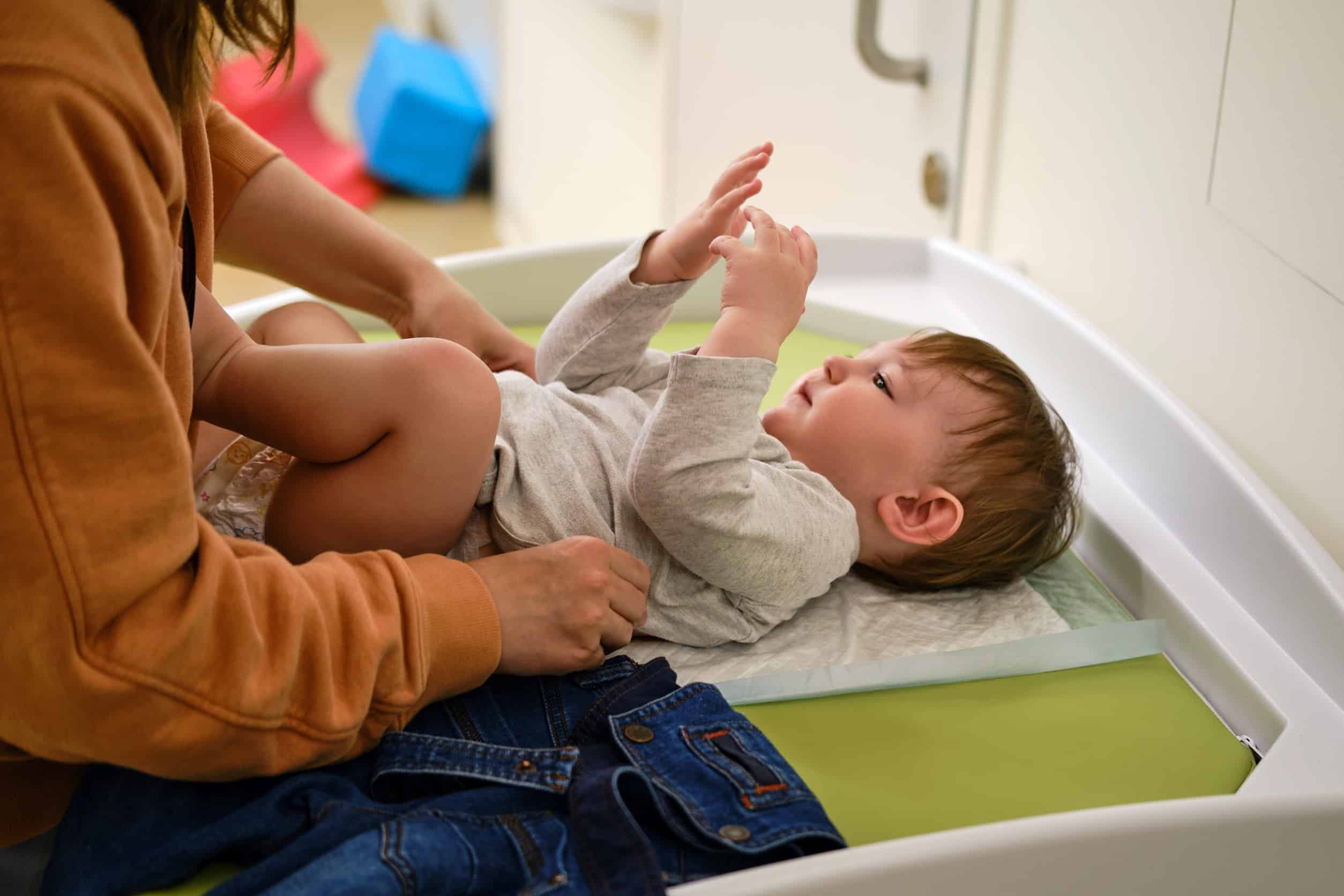 mom putting baby on a changing table