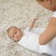 mom wrapping baby on a blanket