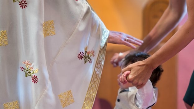 priest blessing a kid