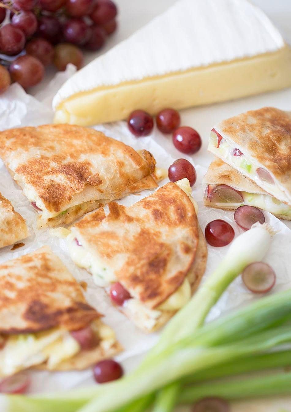 Quesadilla with melted brie, sweet grapes, and scallions.
