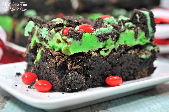 Bar of brownie topped with green ganache and M&Ms.