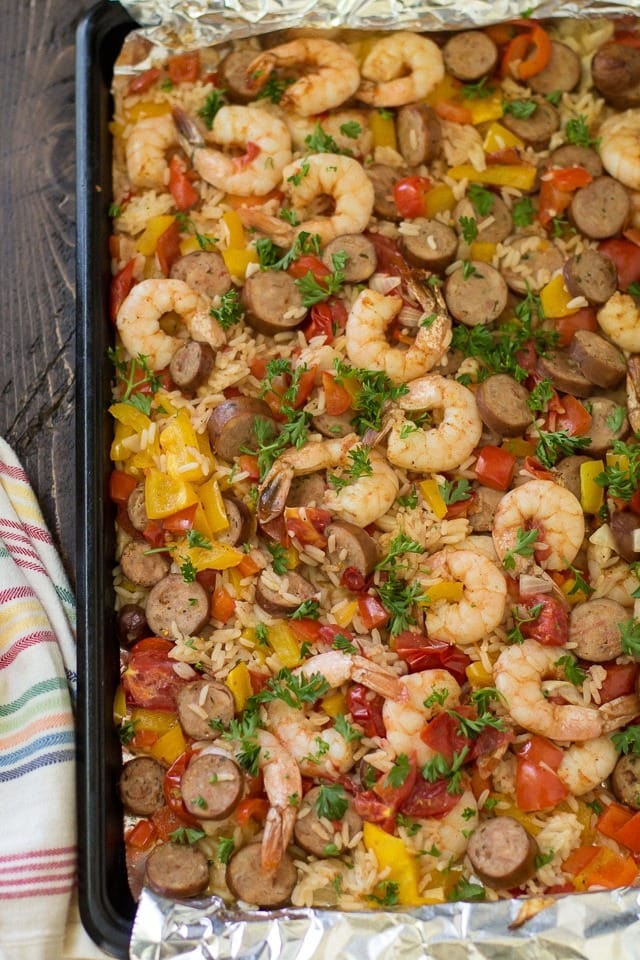 Jambalaya with onion, bell peppers, and sausage served on a sheet pan.