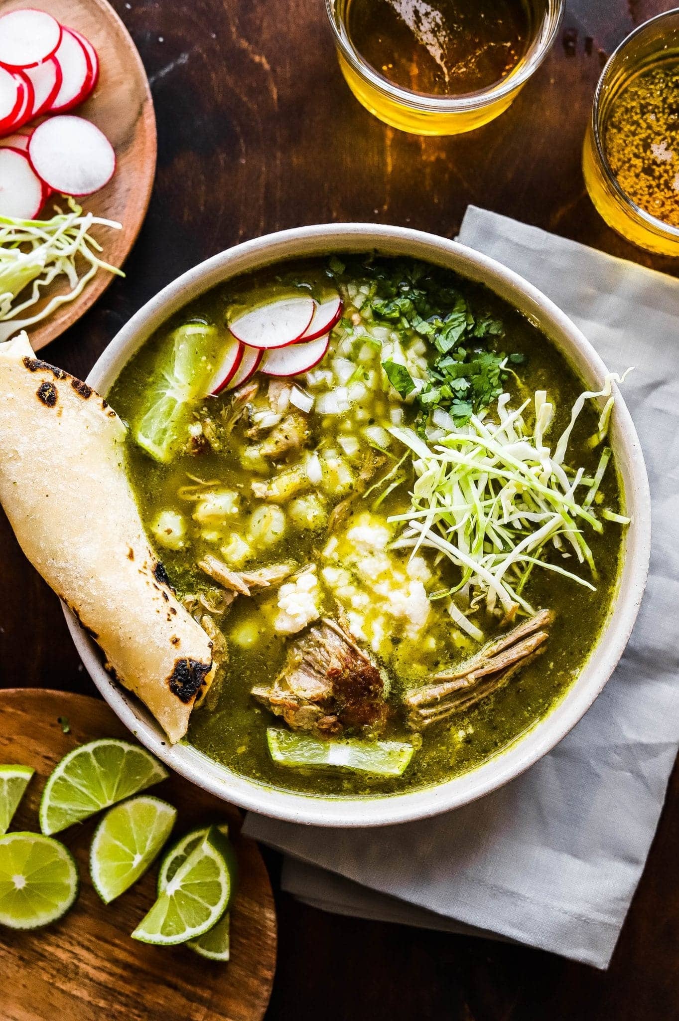 pork-pozole-verde Feta bread dipped on a bowl of Pork Pozole Verde