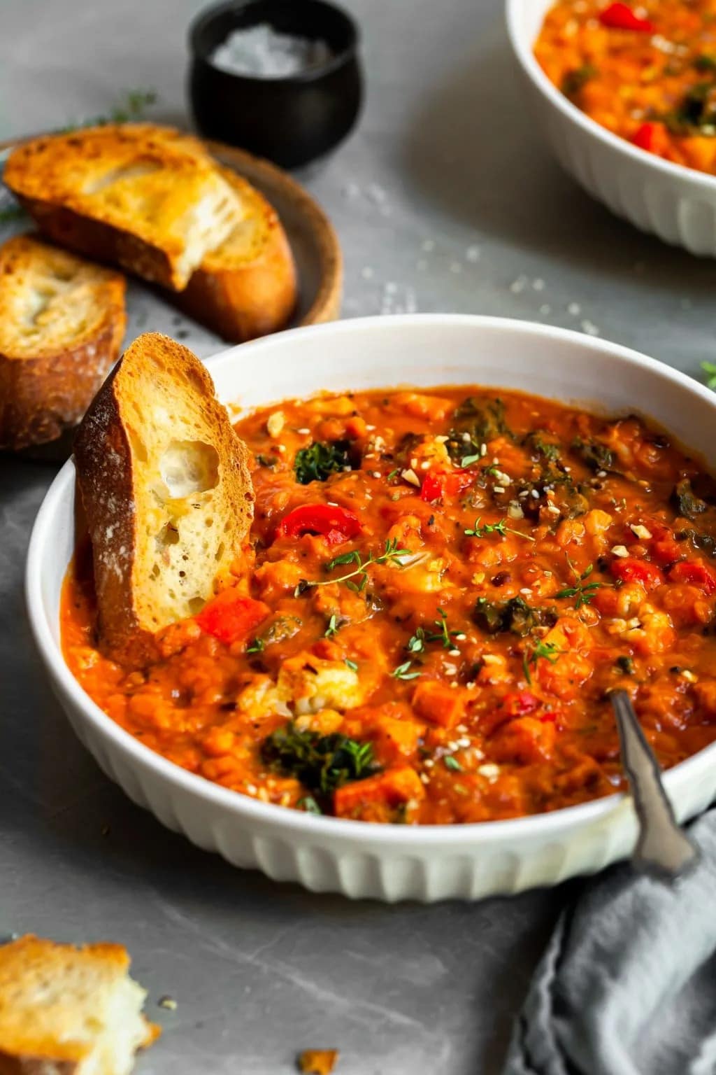 roasted-vegetable-and-red-lentil-stew Toasted French bread dipped on a bowl of Roasted Vegetable and Red Lentil Stew