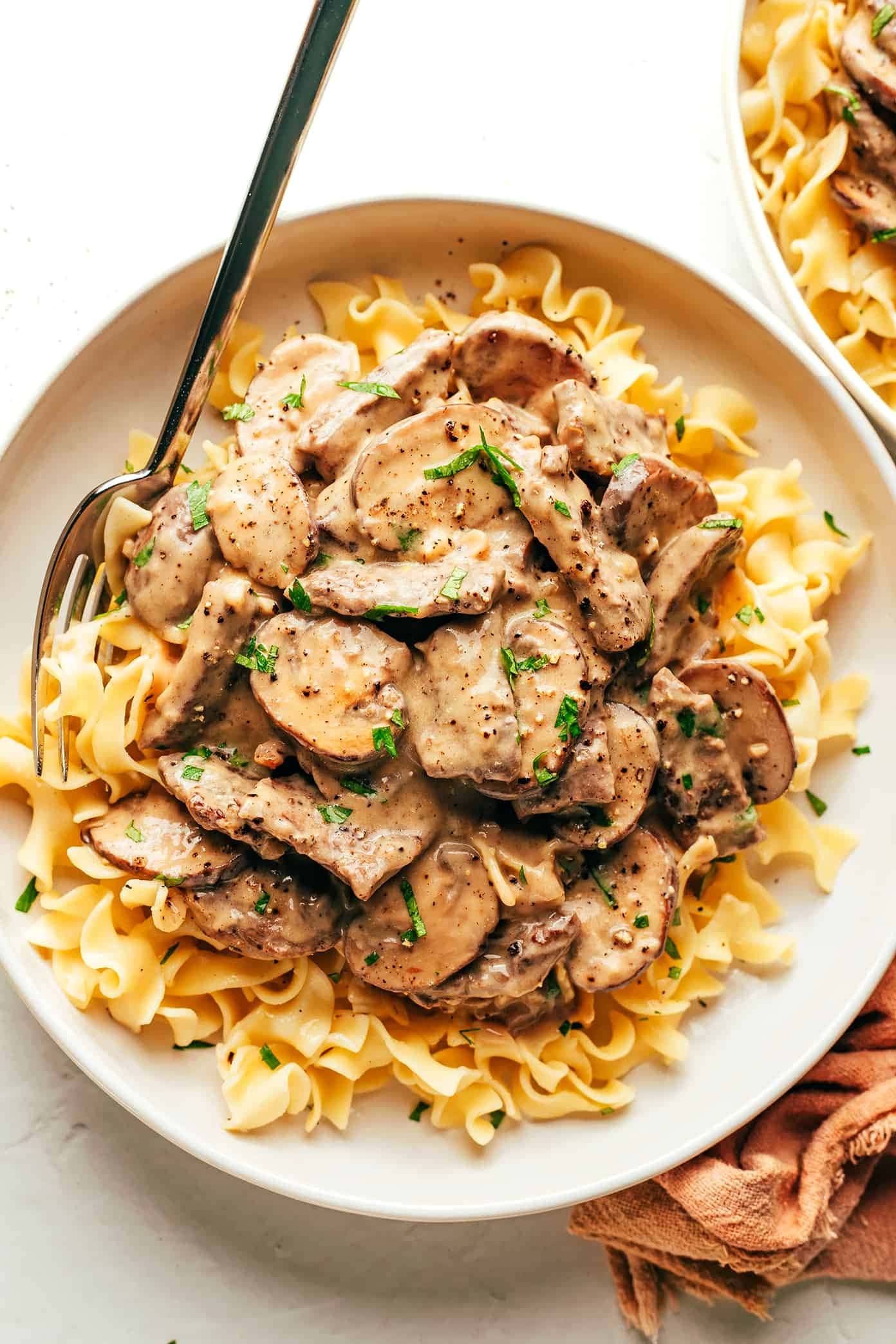 beef-stroganoff Top view of a serving of beef stroganoff served on top of noodles.