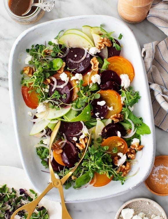 beet-salad Roasted beet salad with mixed with pear, walnuts, and feta layered over leafy green and micro-sprouts.
