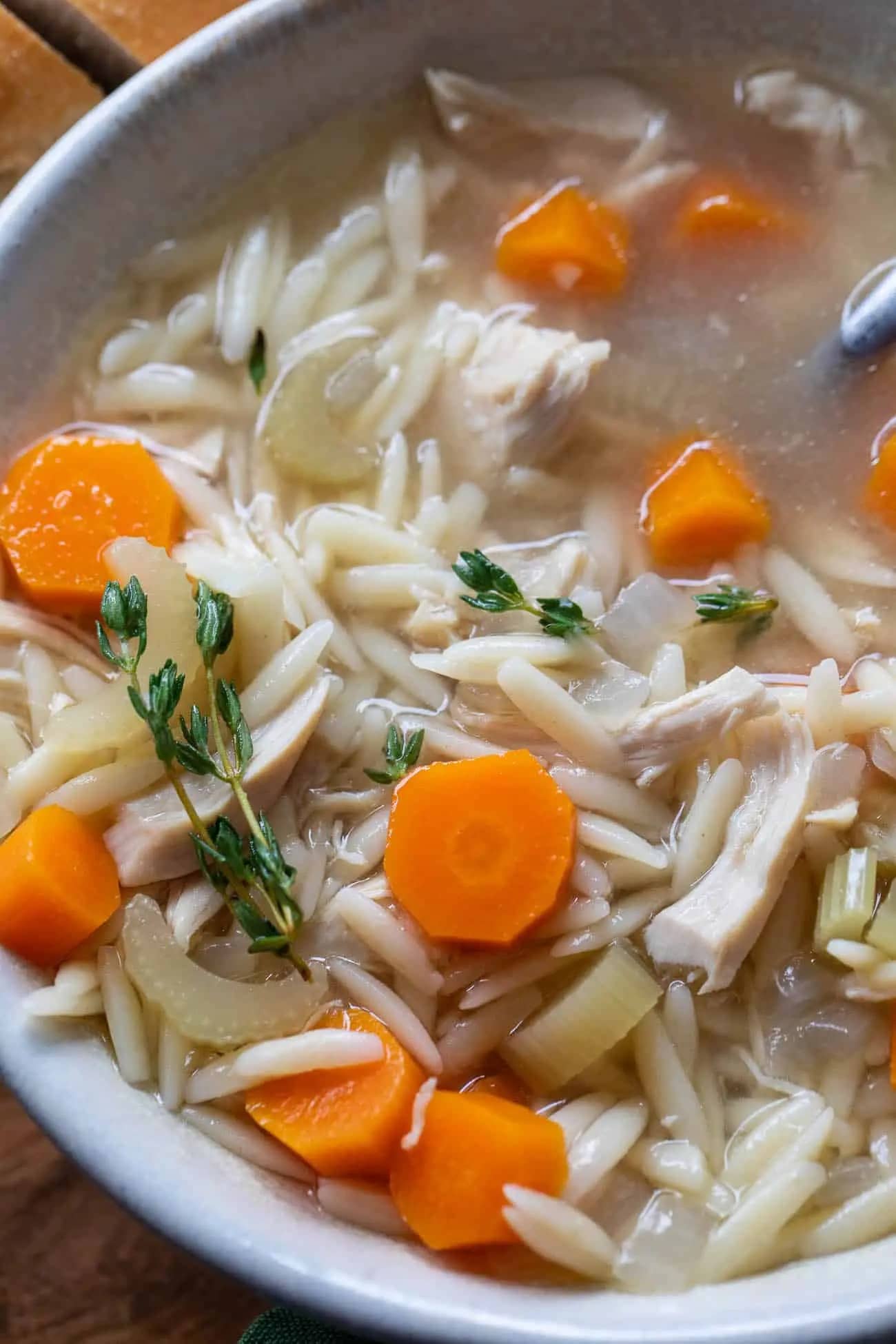 crockpot-chicken-orzo-soup Closeup of chicken orzo soup in a white bowl.