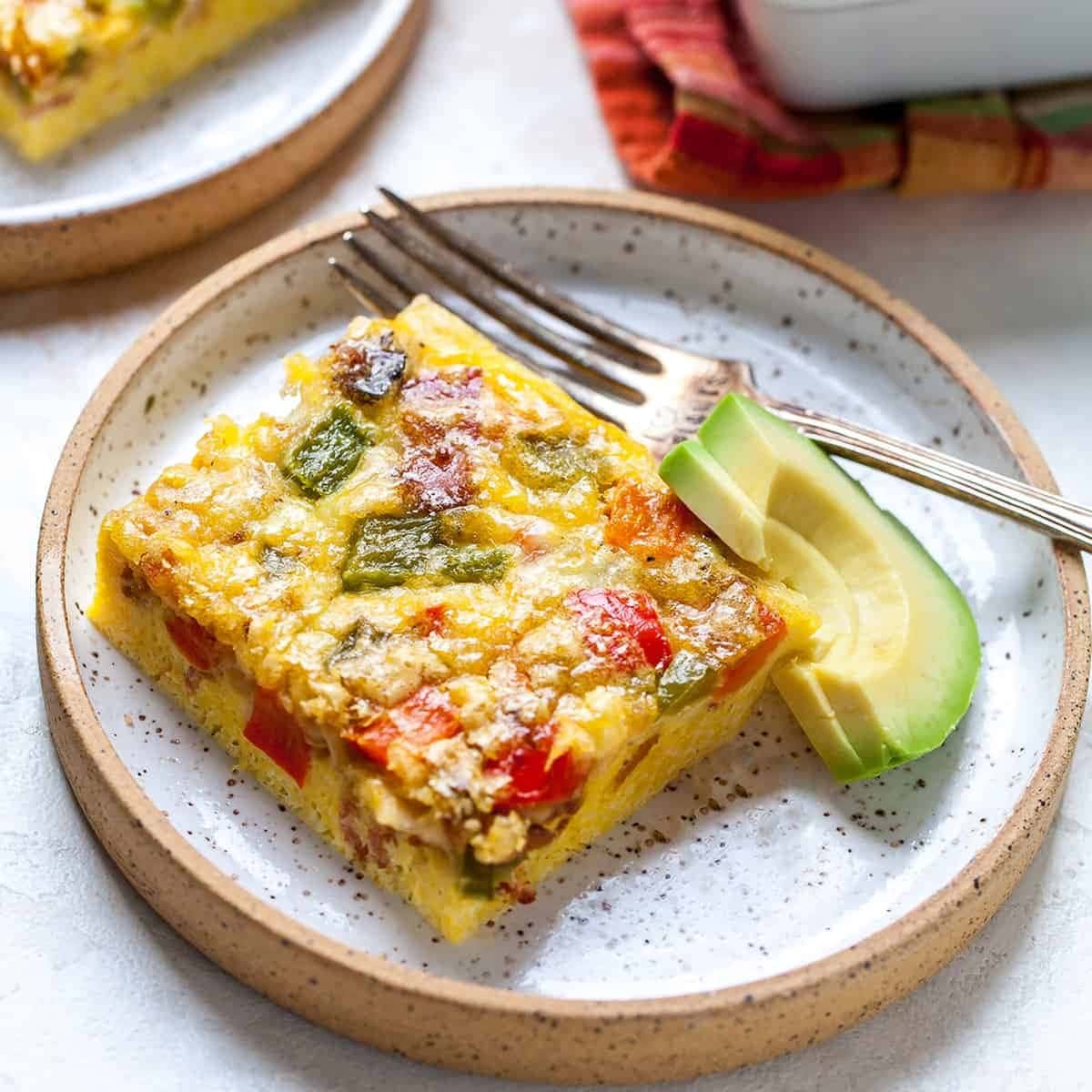 egg-casserole-recipe Egg bake casserole served on a plate made with bacon, bell peppers, and eggs.