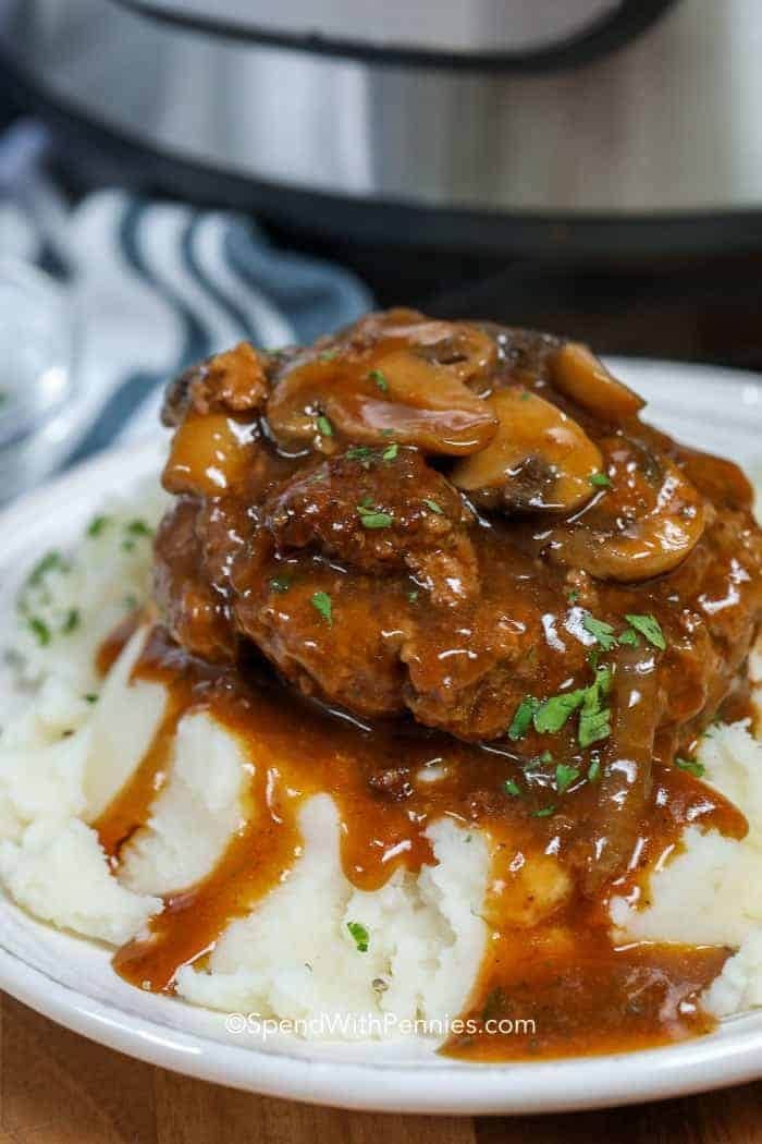 instant-pot-salisbury-steak Salisbury steak on top of mashed potatoes.