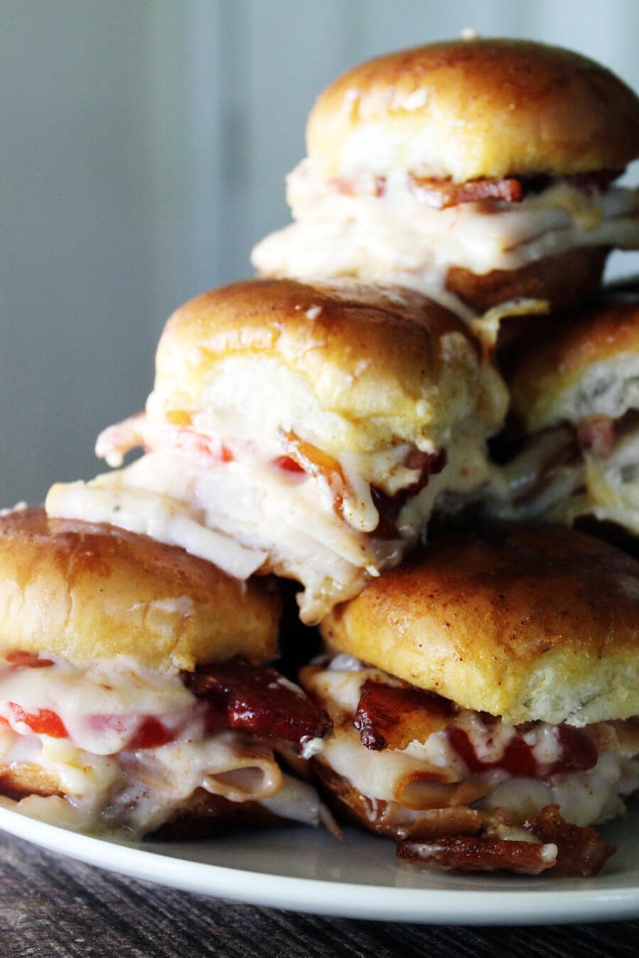 Bunch of sliders made with tomatoes, cheese and turkey.