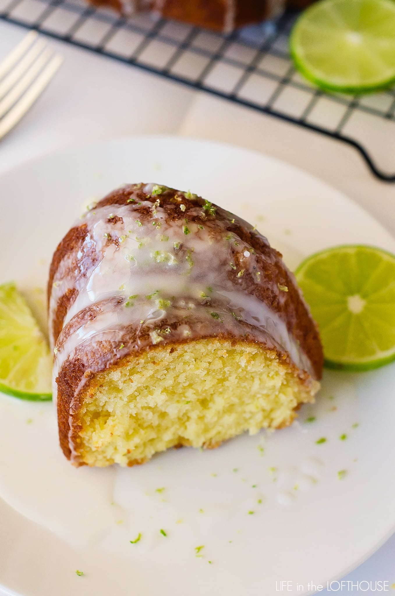 key-lime-bundt-cake Slice of key lime Bundt cake on a plate with lime glaze and slices of lime.