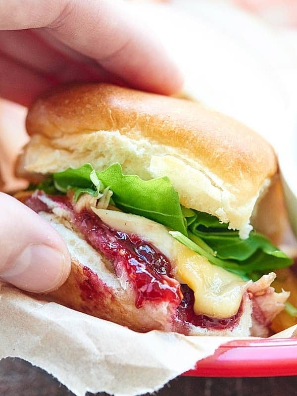 Sandwich made with leftover rolls, shredded turkey, gravy, gouda cheese, raspberry jam, and arugula.