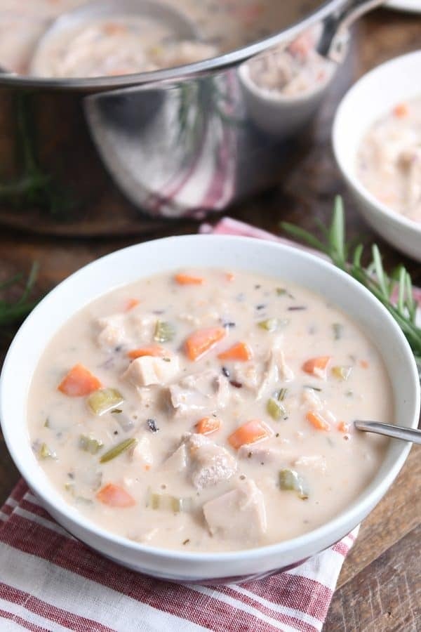A bowl of turkey soup loaded with rice, turkey chunks and veggies.