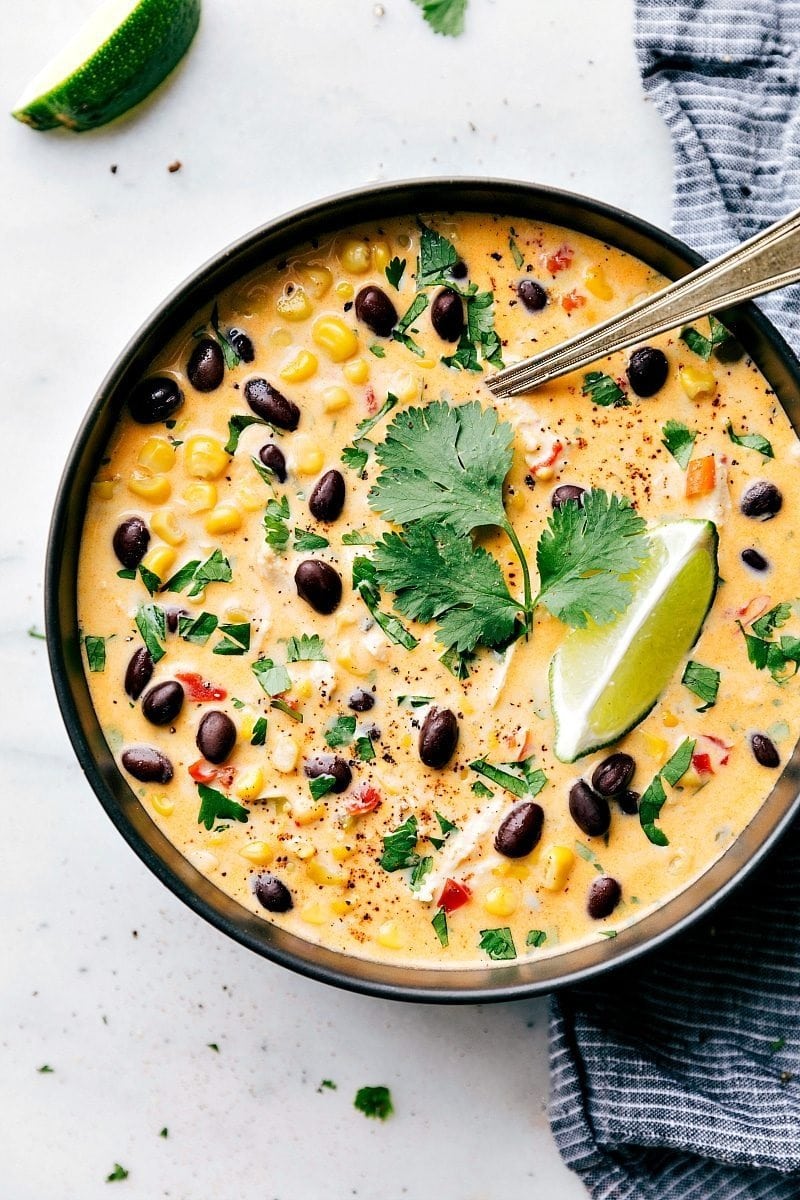 mexican-street-corn-chowder Mexican corn and chicken chowder served on a black bowl with spoon.