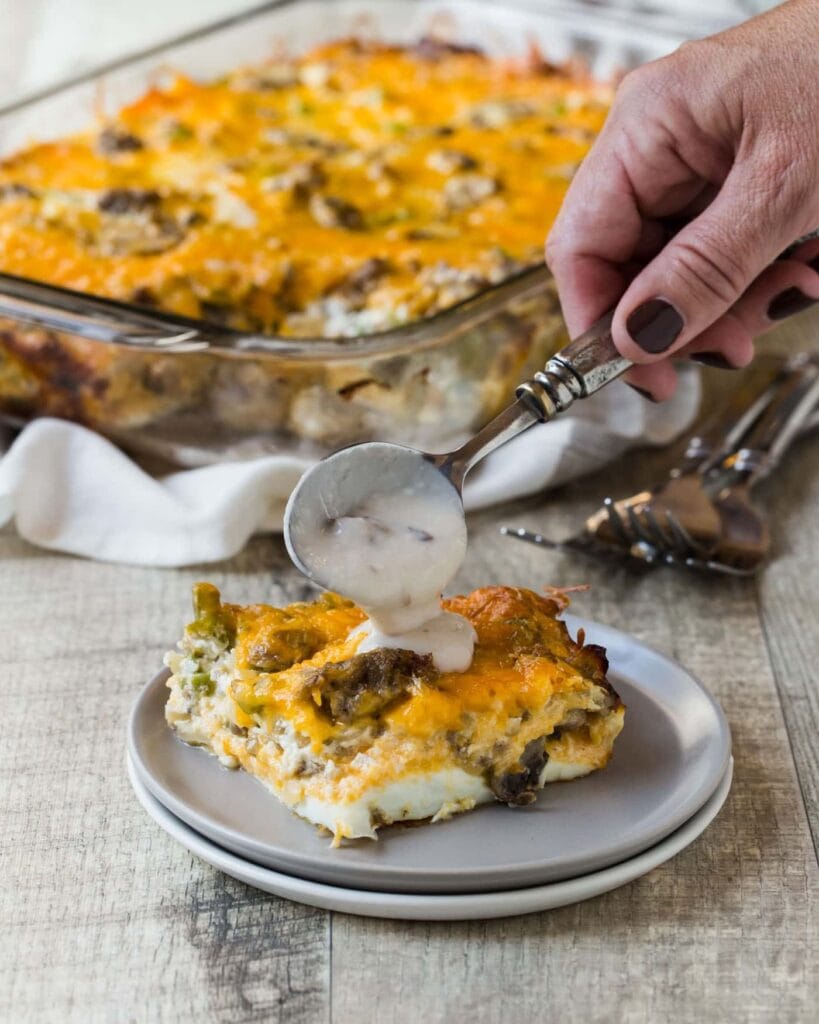 overnight-firemans-breakfast-casserole-819x1024-1 A slice of overnight fireman's breakfast casserole with sausage drizzled with mushroom sauce.