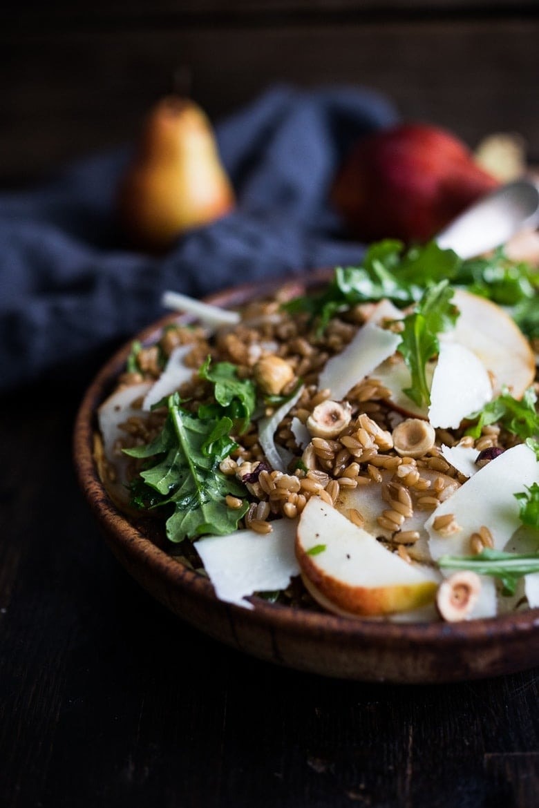pear-and-farro-salad Toasted farro salad with pear, hazelnuts and arugula in a wooden bowl.