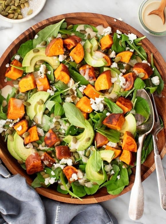 sweet-potato-salad Sweet potato salad in wooden bowl with roasted sweet potato, feta, avocado, and leafy spinach.