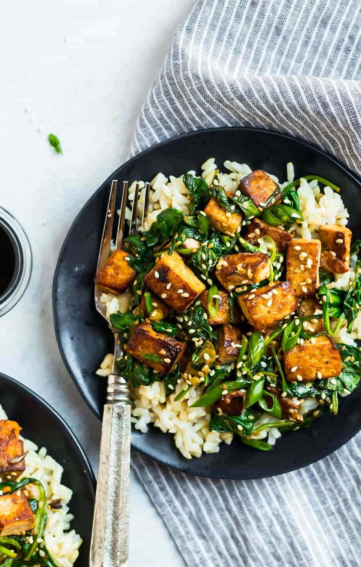 tofu-stir-fry Rice topped with stir fry tofu sprinkled with sesame seeds.