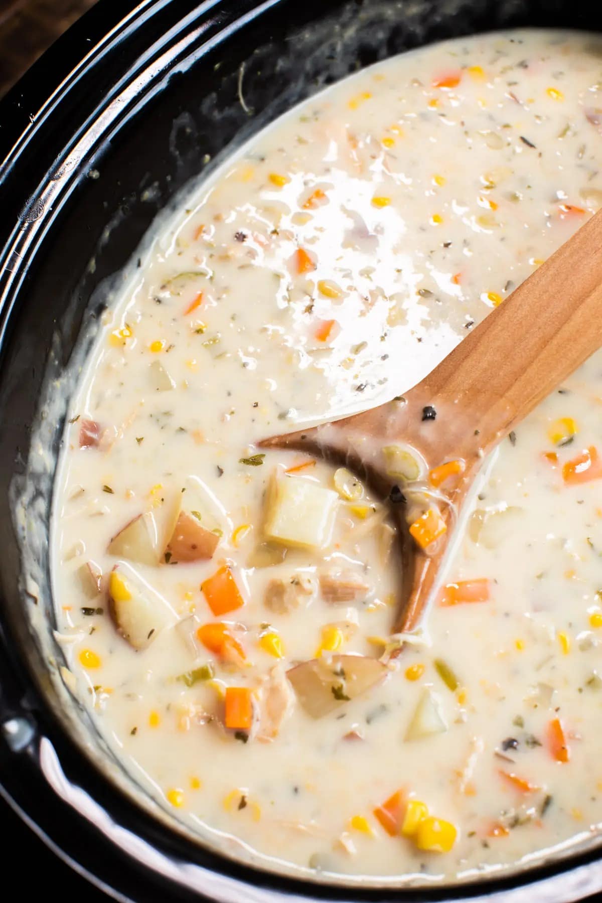 Chowder with creamy soup with turkey meat, corn and veggies cooked in a slow cooker.